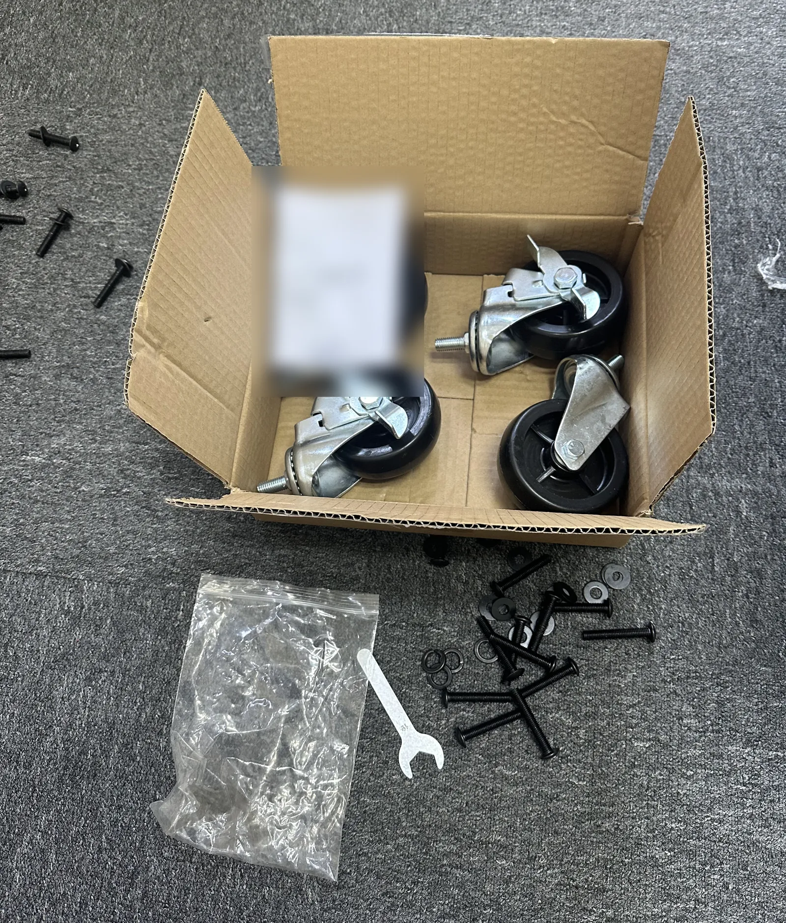 Castors, bolts, washers and a spanner packed as an assembly kit for a cart