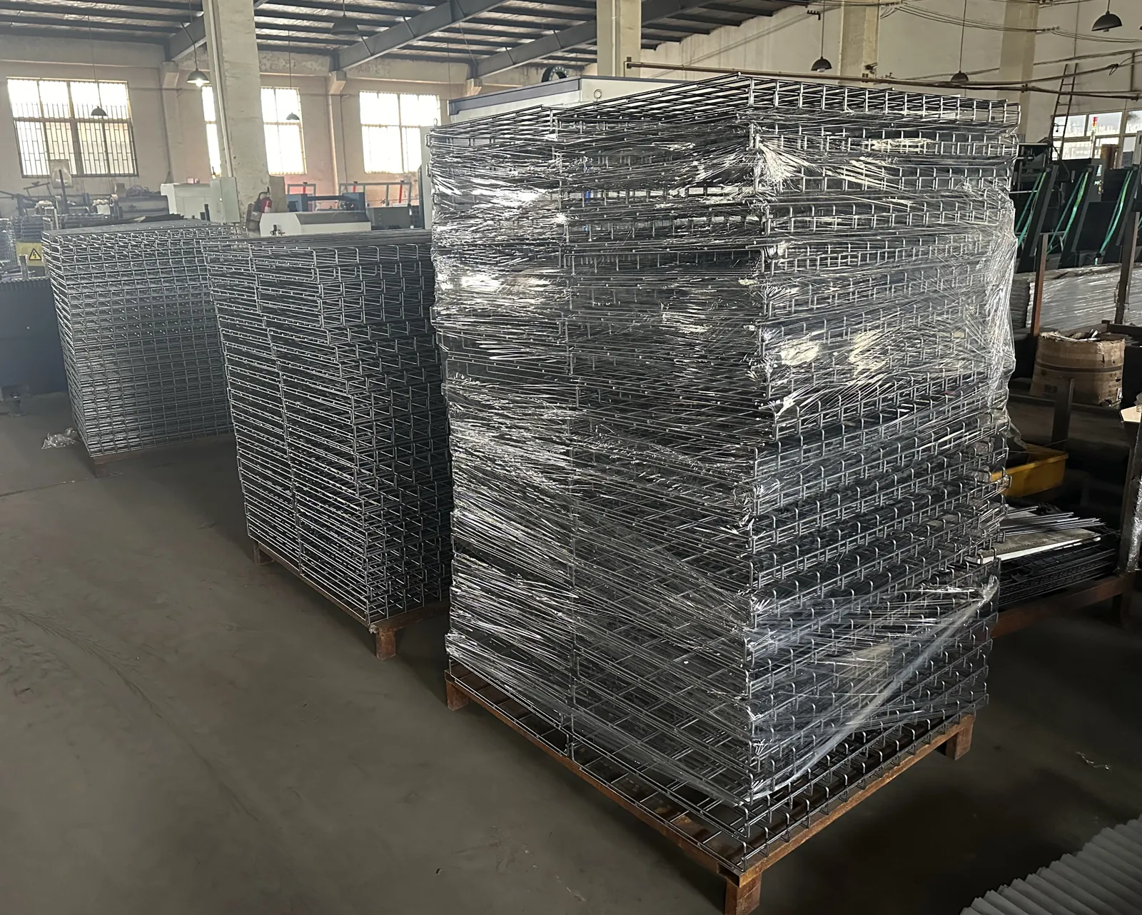 Wire baskets stacked and wrapped on pallets at a metal fabrication factory
