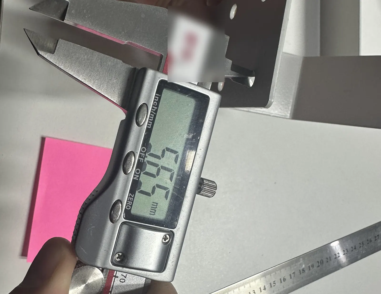 Owl Sourcing team member measuring a part with a digital caliper during quality control in China