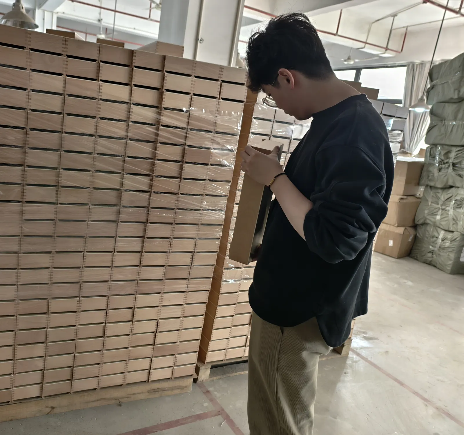 Owl Sourcing team member checking a stack of finished wooden boxes